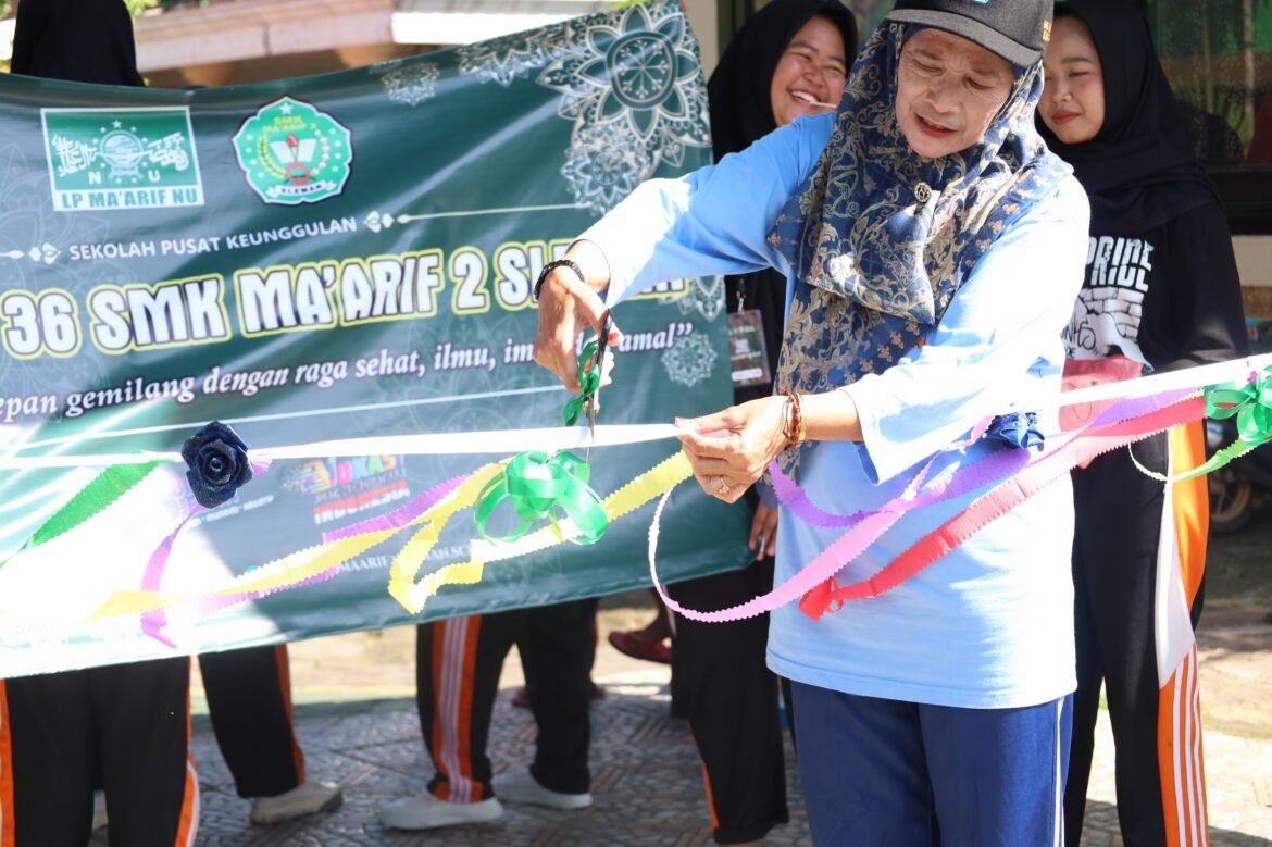 Foto Dra. Atik Sunaryati selaku Kepala Sekolah SMK Ma’arif 2 Sleman ketika pemotongan pita tanda dibukanya acara
